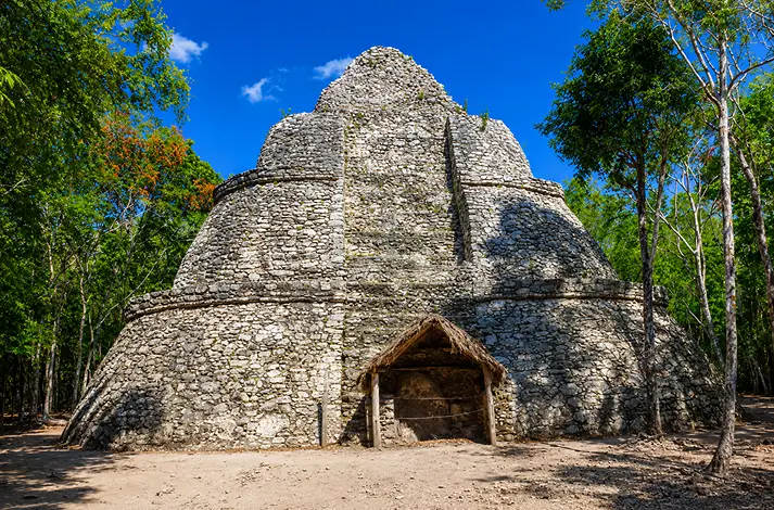 Ancient Mayan stone pyramid at Cobá Archaeological Site near Tulum surrounded by tropical jungle